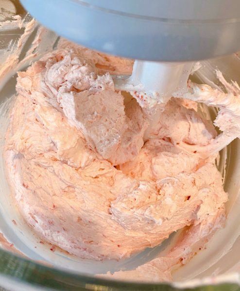 Creamy Raspberry Buttercream in mixing bowl ready to spread on cupcakes.