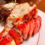Air Fried Lobster Tail on a China Plate drizzled with lemon butter.