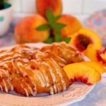 Fresh Peach Fritters on a white plate with fresh peach slices.