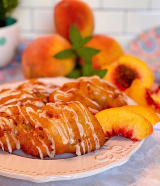 Fresh Peach Fritters on a white plate with fresh peach slices.