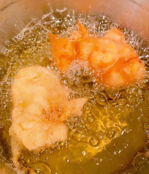 Frying Peach Fritters in hot oil. 