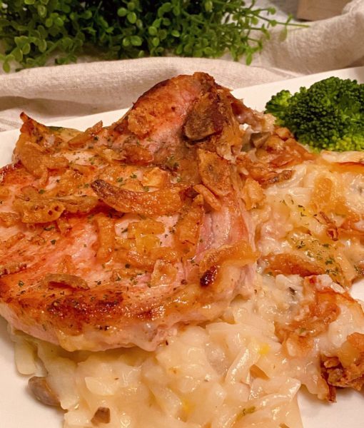 Pork Chop and Creamy Potato serving on a dinner plate with spears of broccoli.