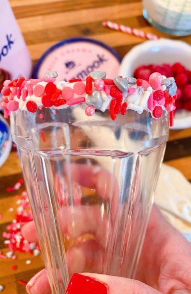 Rim of glass coated in valentine sprinkles.