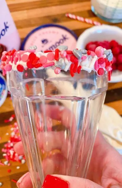 Rim of glass coated in valentine sprinkles.