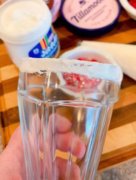 Milkshake glass with marshmallow cream rubbed around the rim.