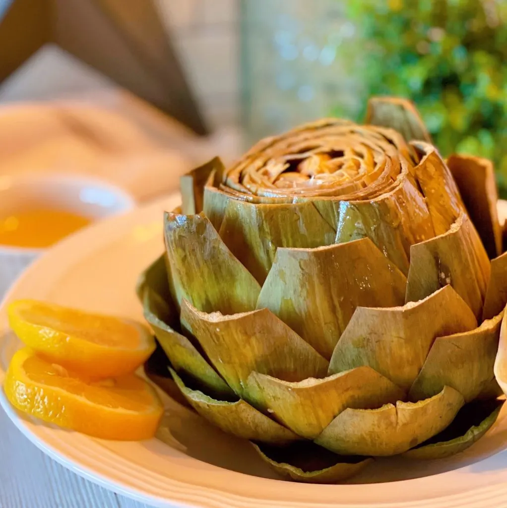 Cooked artichoke in serving bowl.