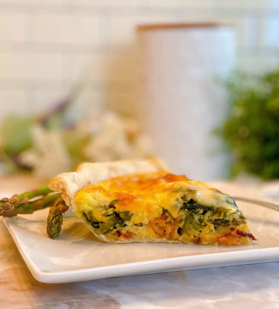 Asparagus Mushroom Quiche sliced on a beautiful white plate.