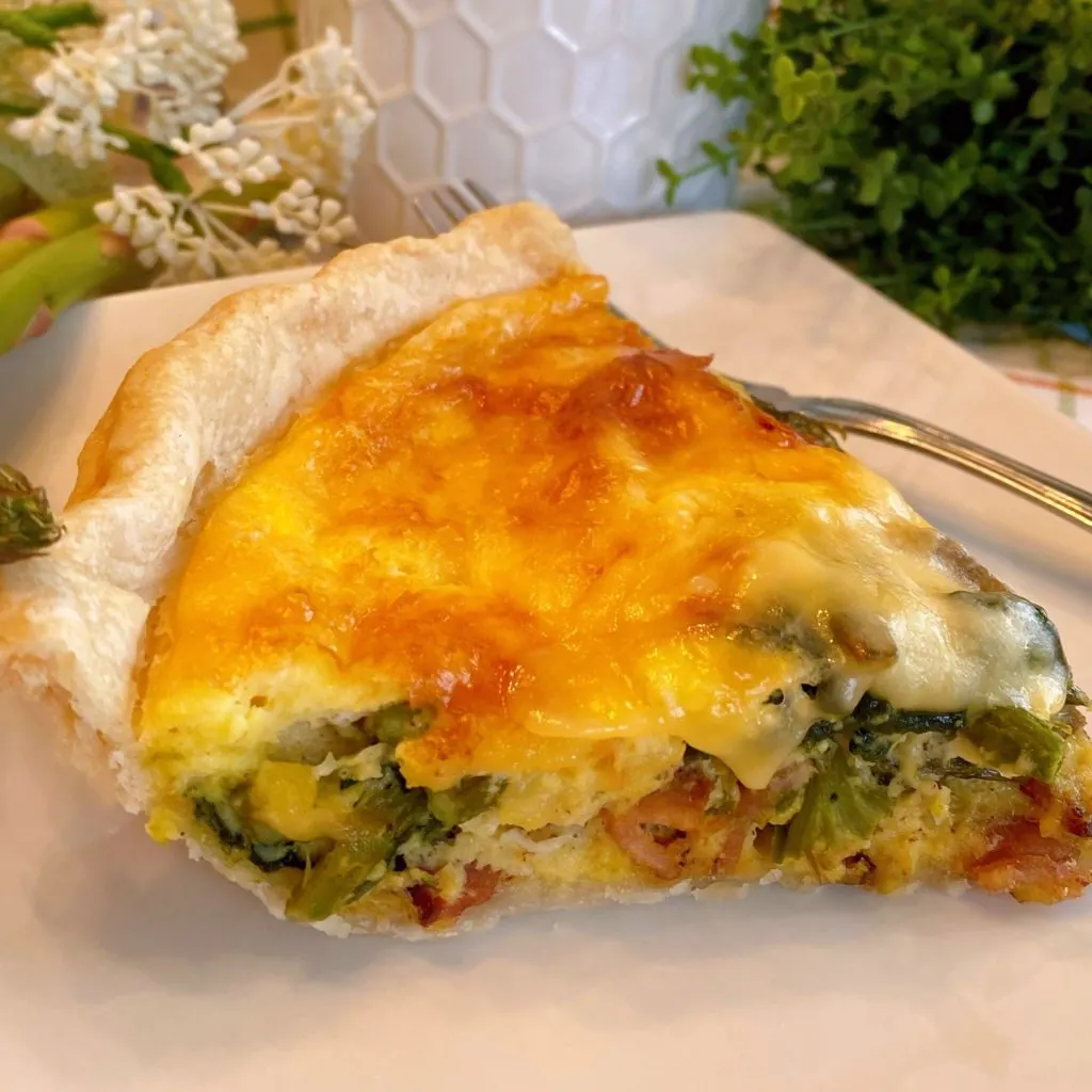 Slice of Asparagus Quiche on a plate with a fork.