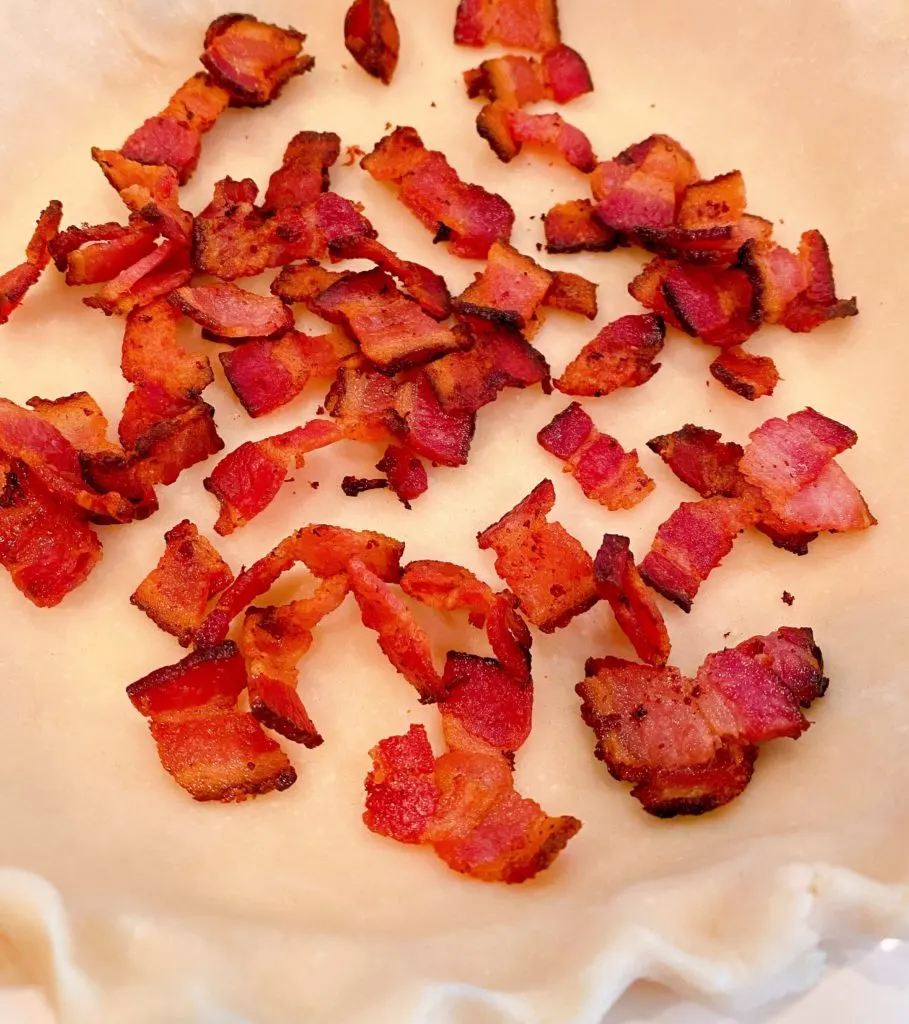 bacon pieces in bottom of pie crust.