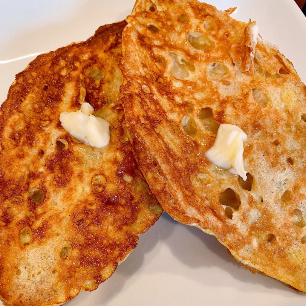 Cooked French Toast on a plate with butter.