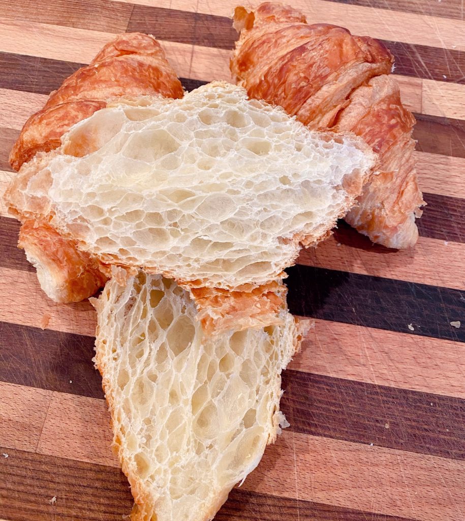 Croissants sliced in half on the cutting board.
