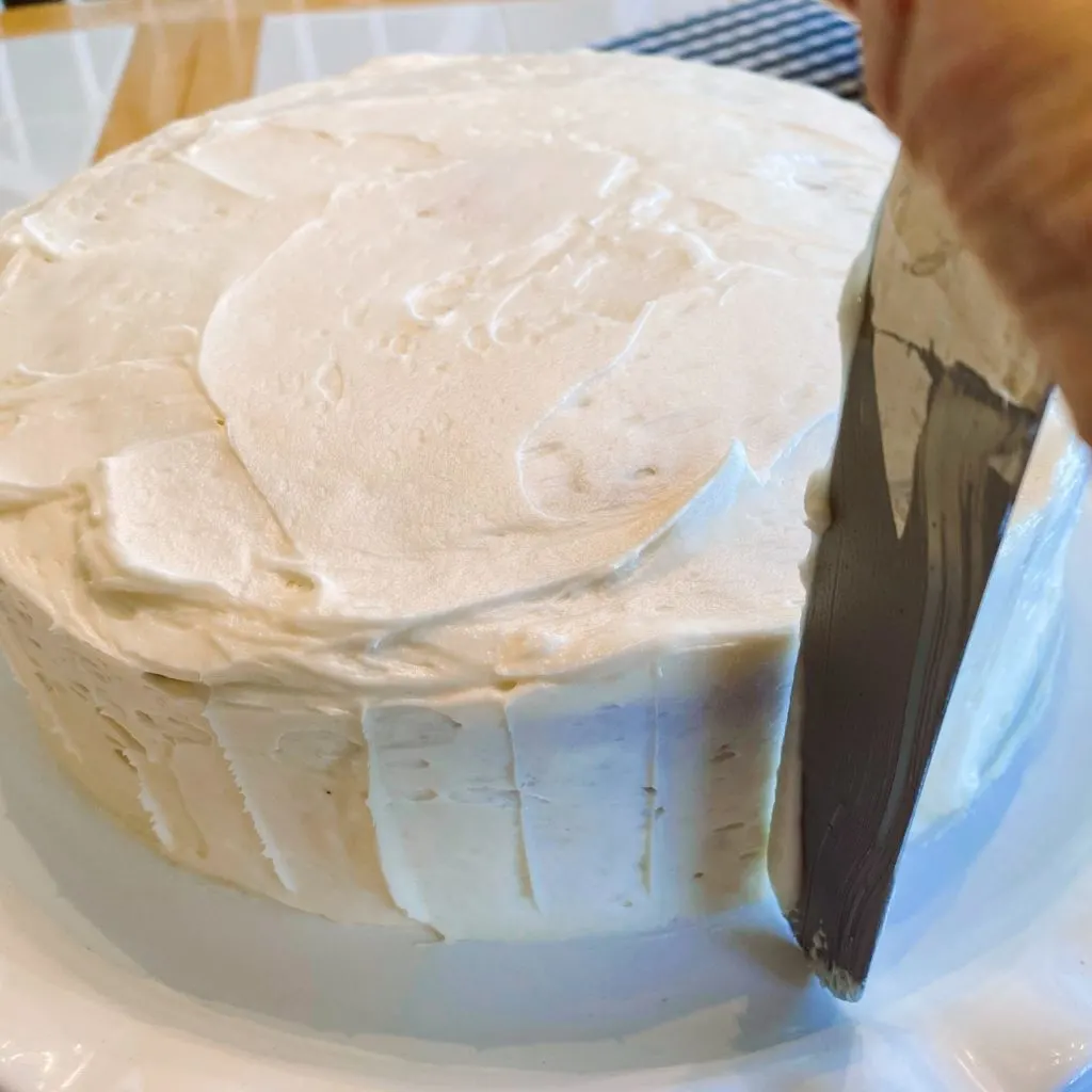 Crumb coat of vanilla frosting on the cake and marks to help with pipping.