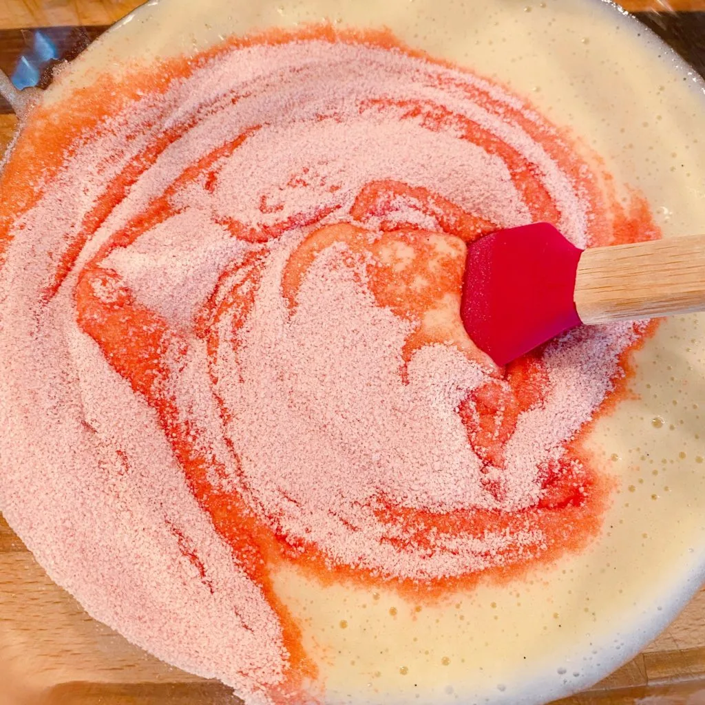 Adding strawberry jello to the cake batter.