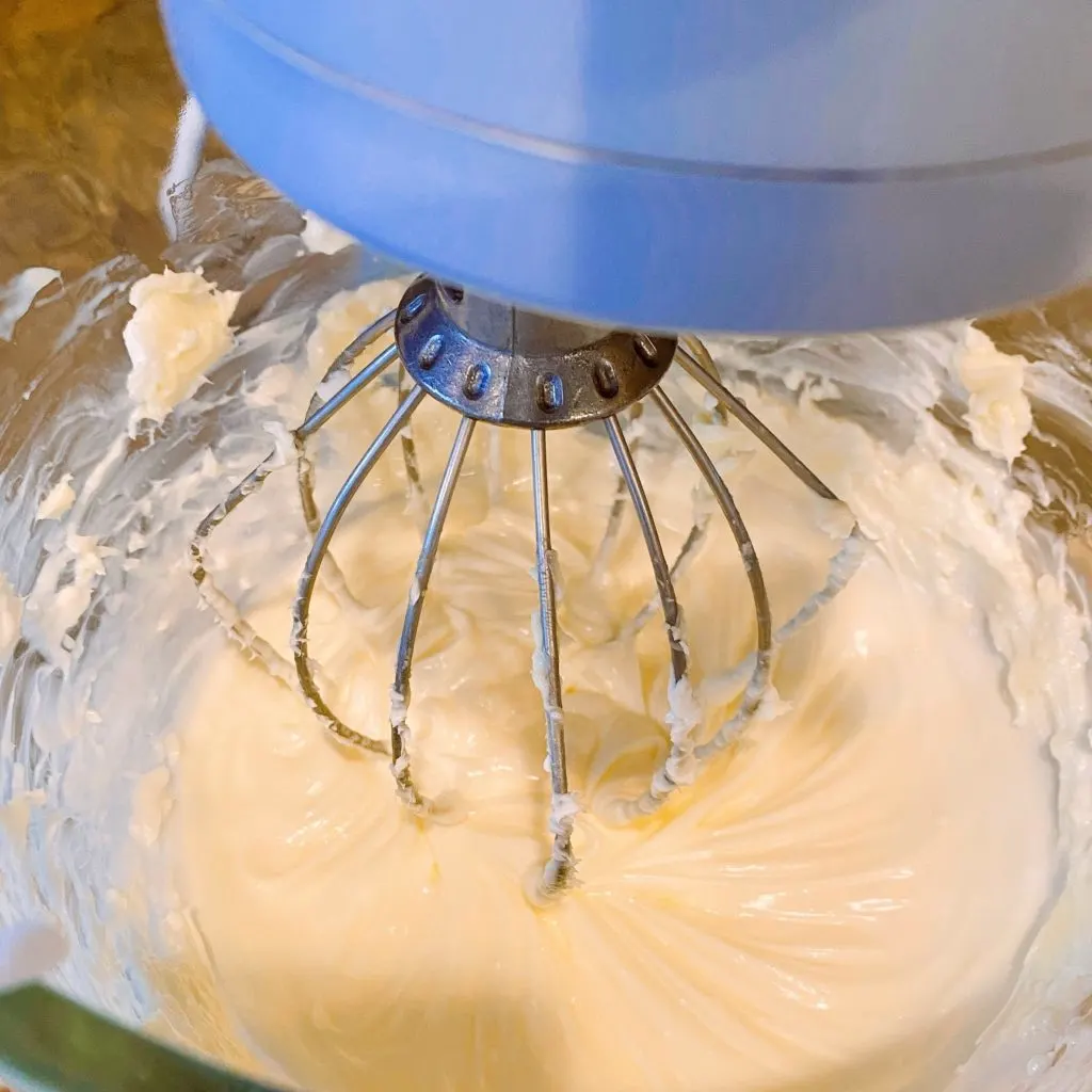Mixing frosting ingredients in mixing bowl of stand mixer.