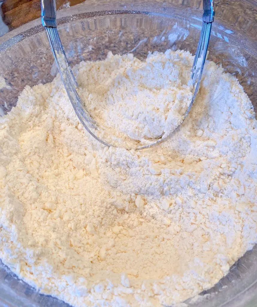 Cutting butter into dry ingredients with a pastry blender.