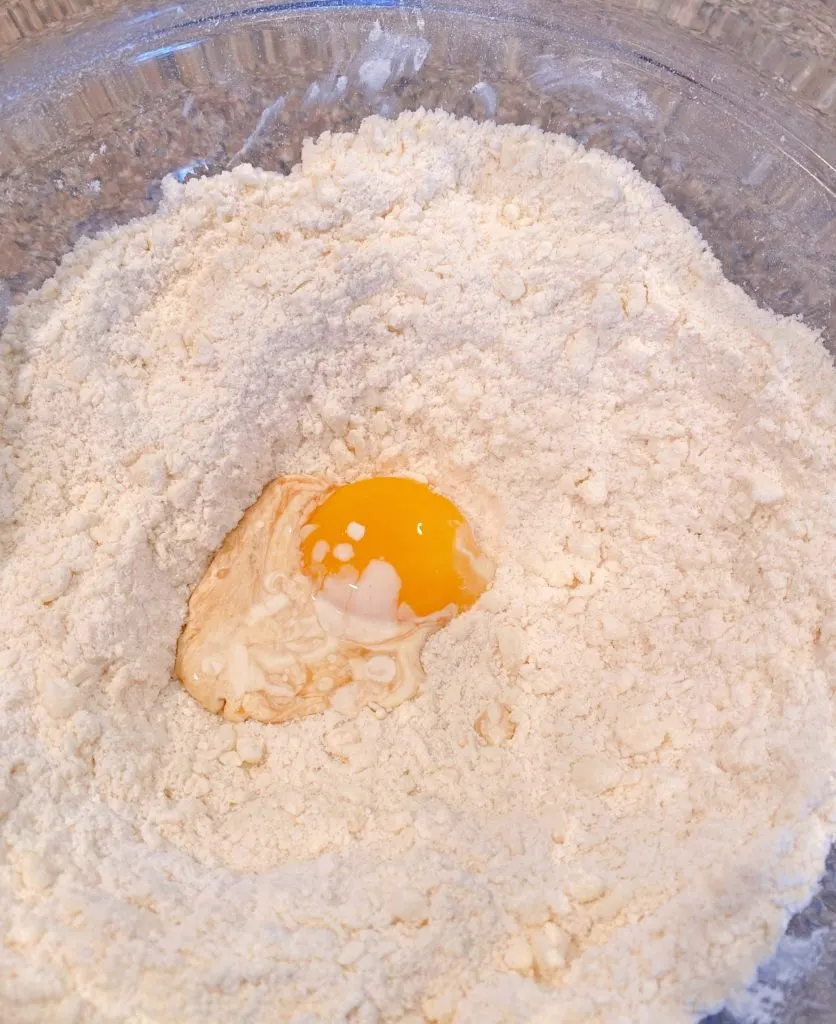 Adding wet ingredients to the dry ingredients for the shortbread crust.