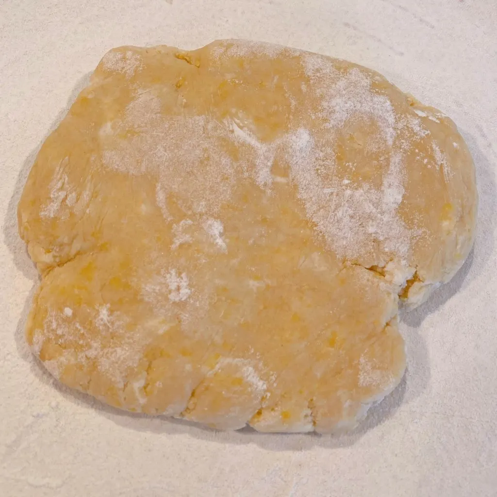 Rolling the dough on a dough disc to create the short bread tartlet crusts.