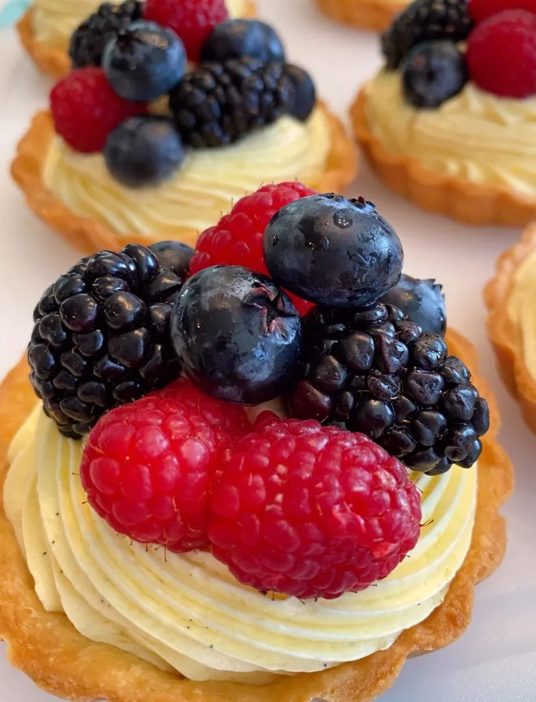 Topping each tartlet with fresh berries.