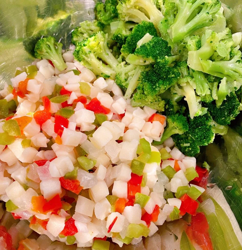 Thawed hash browns and broccoli in a large mixing bowl.