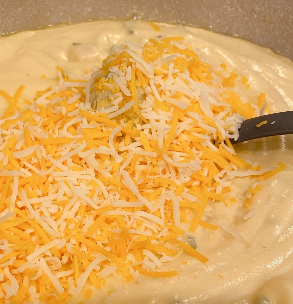 Adding cheese to cream cheese sauce.