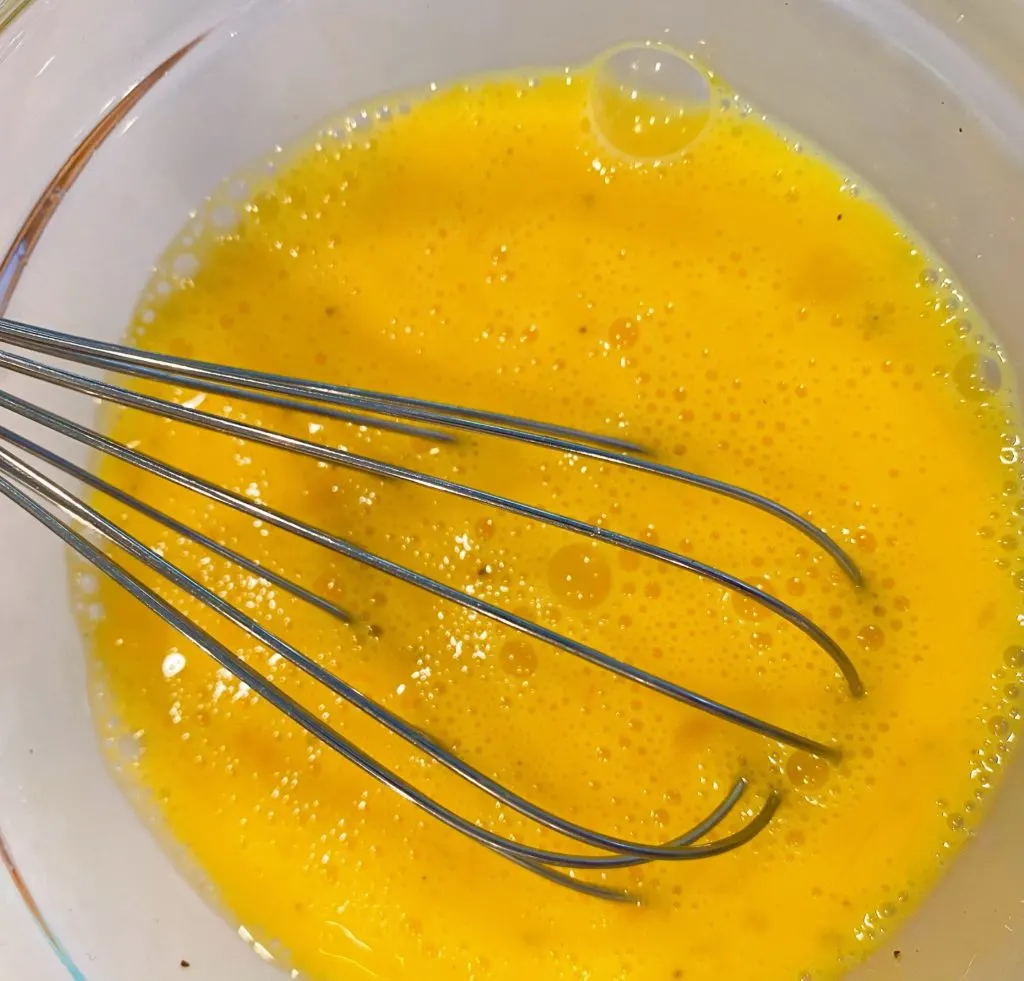 Whisk whisking eggs in a small bowl. 