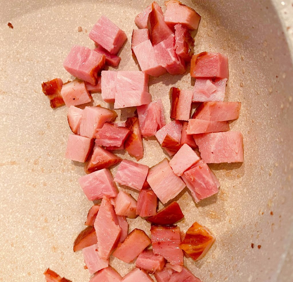 small skillet with one cup chopped ham browning in the skillet.