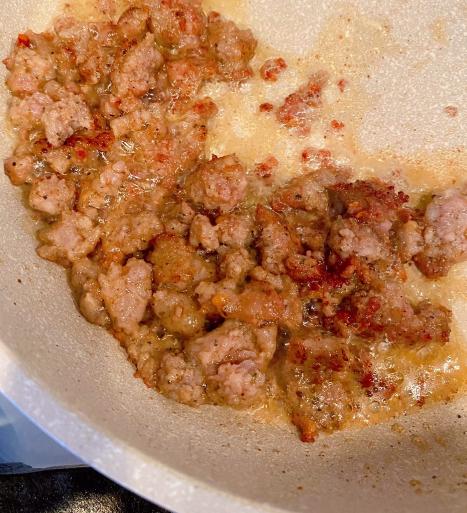 Browned breakfast sausage in a skillet on top of the stove. 