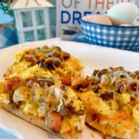 Individual sized breakfast pizzas on a white serving platter.