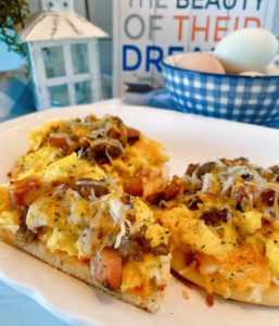 Individual sized breakfast pizzas on a white serving platter.