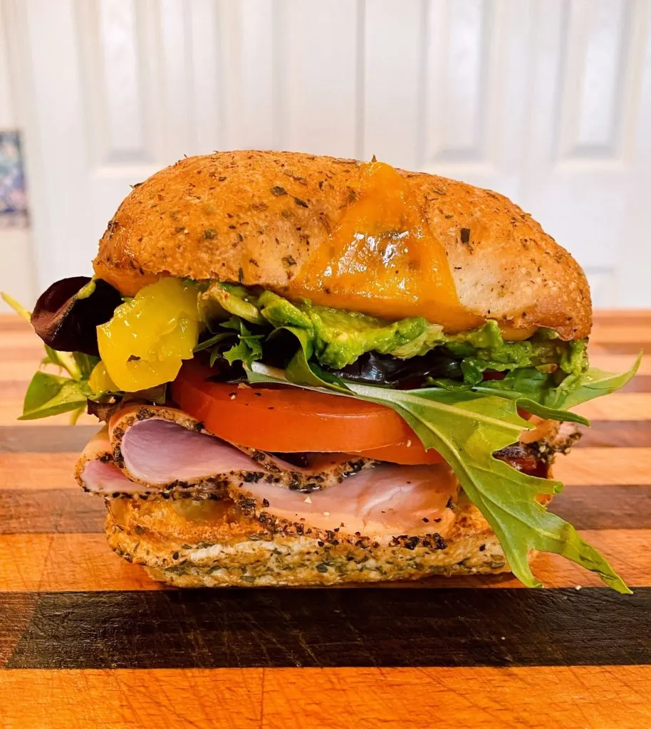 Sandwich put together on the cutting board. The top and bottom pressed together. 