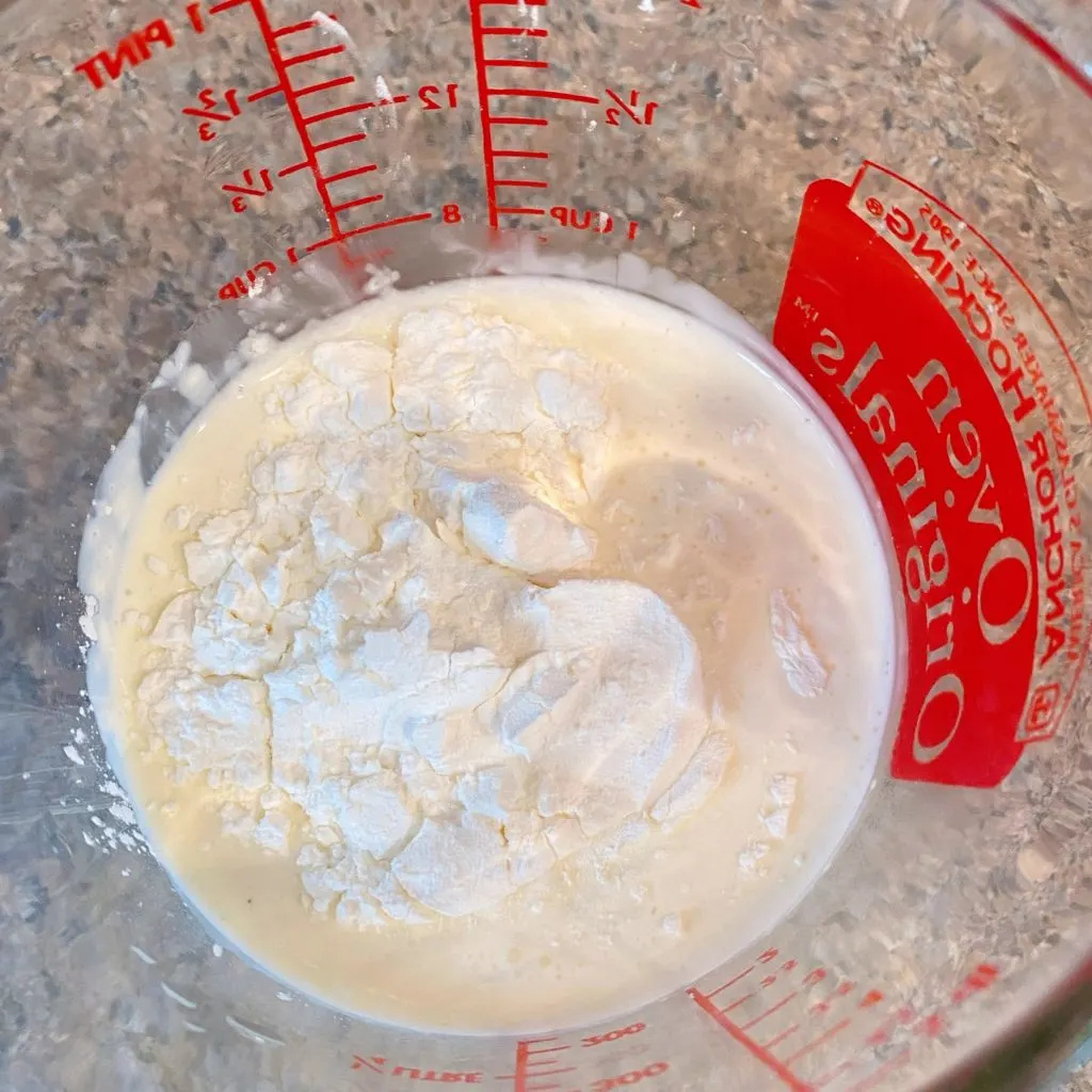 Heavy Cream in a glass measuring cup with cornstarch.