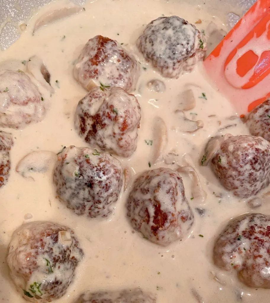 Meatballs in thickened cream sauce resting.