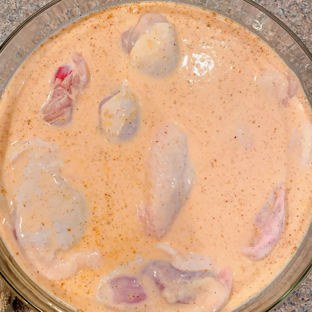 Chicken in the buttermilk mixture soaking.