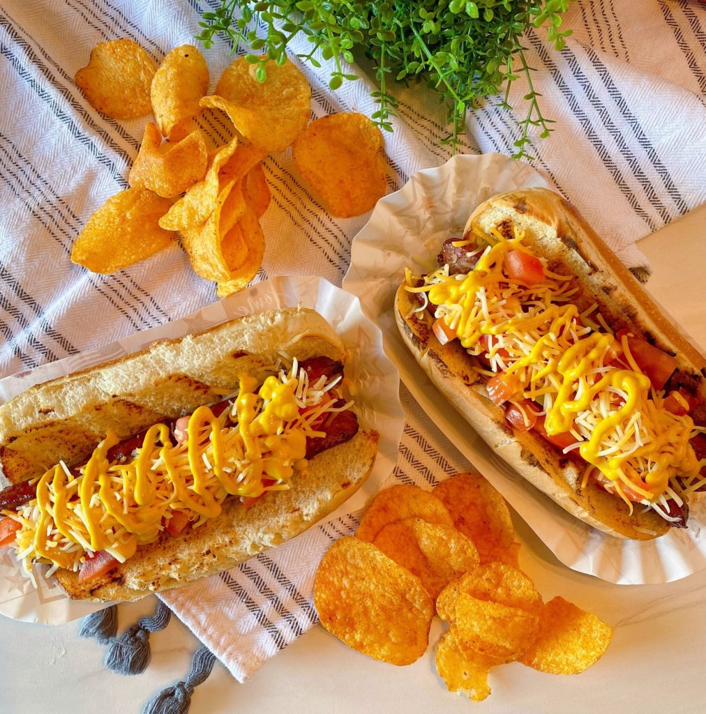 Polish Dogs with chips on a table.