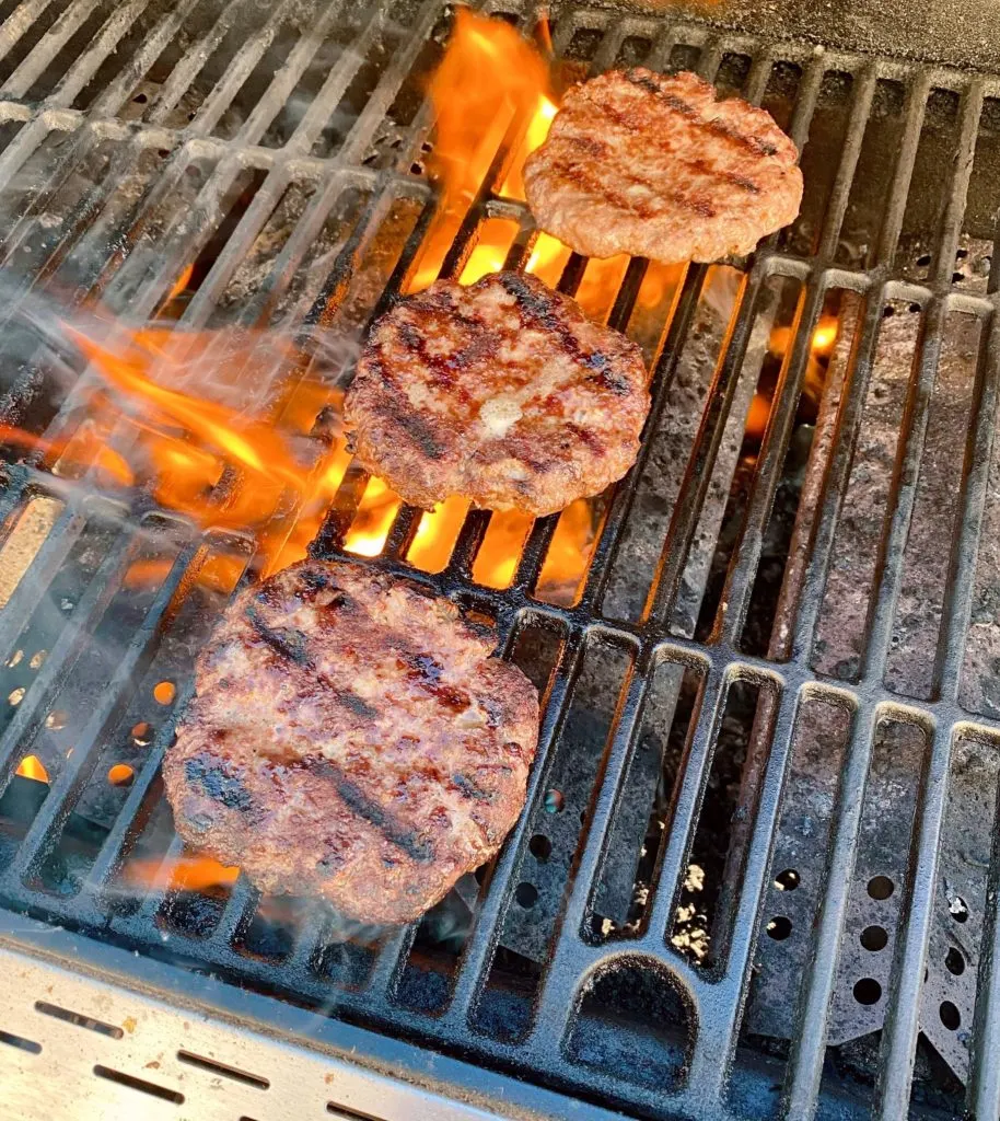 Grilled Hamburgers on the BBQ with flames.