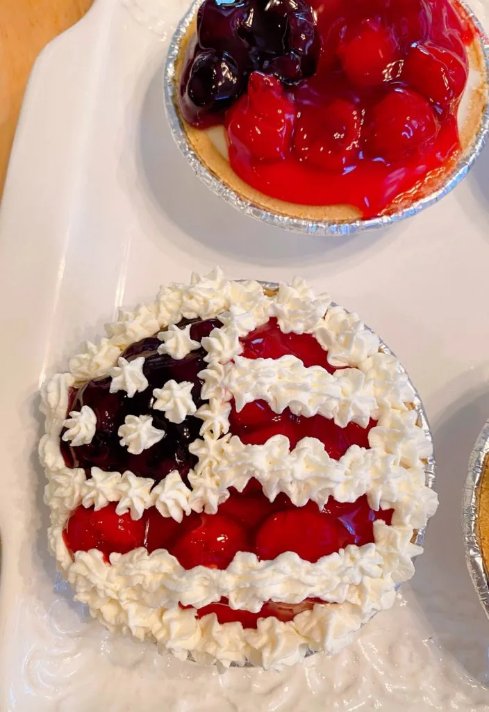 Mini pie with whipped cream piped onto the pie to create the stars and stripes.
