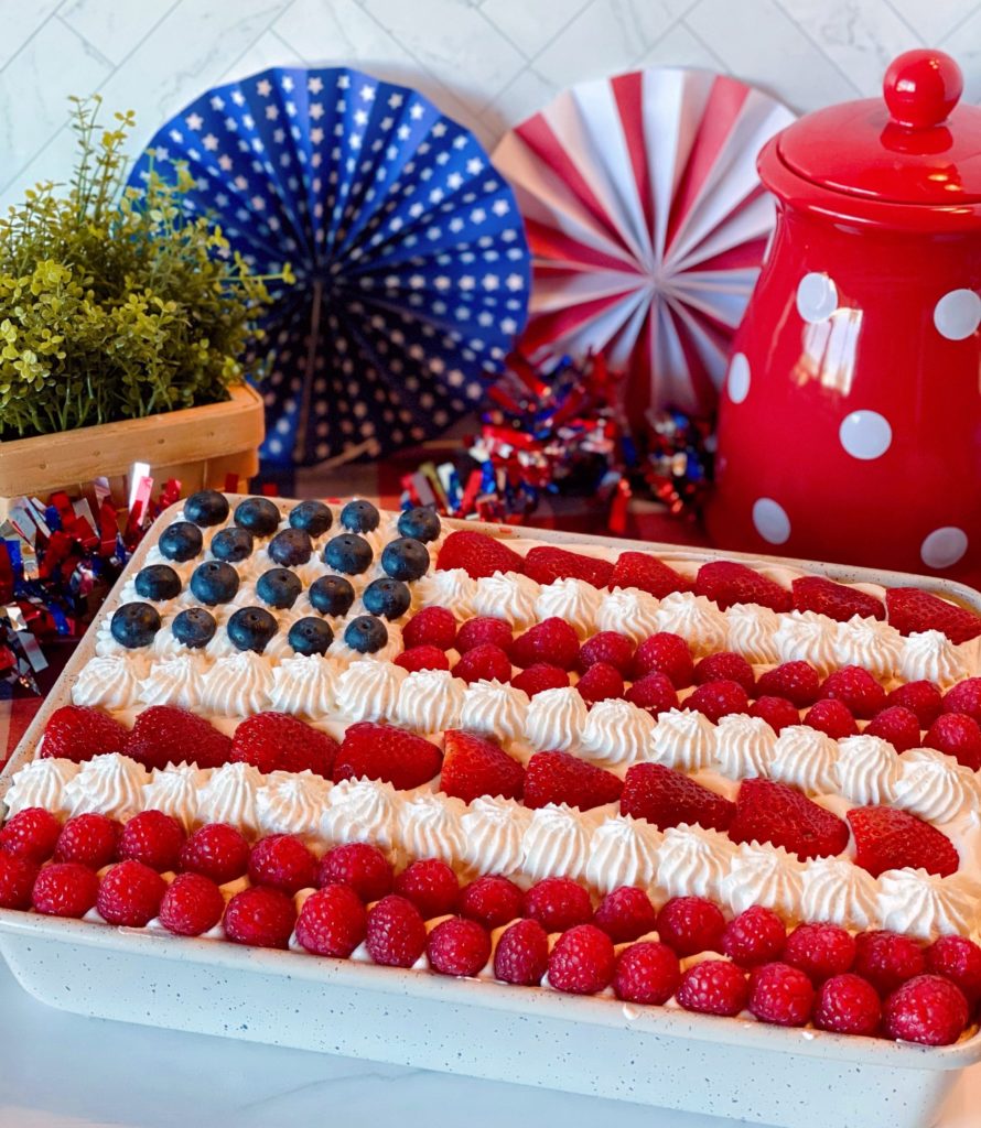 Red, White & Blue Poke Cake with Patriotic Background in a cake pan.