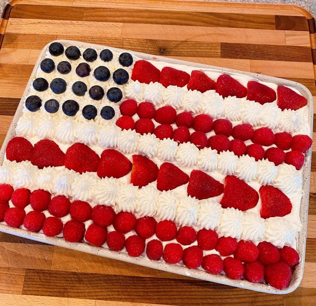 Adding berries to the top of the cake to create a flag.