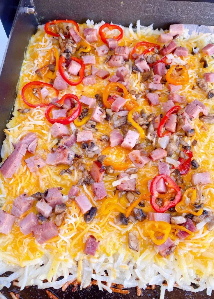 Adding toppings to hash brown omelets.