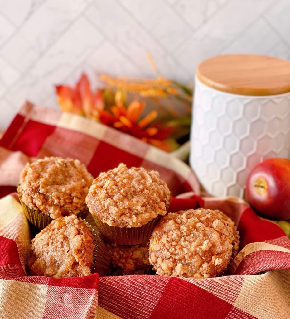 Basket full of Pumpkin Apple Streusel Muffin on a plaid napkin.