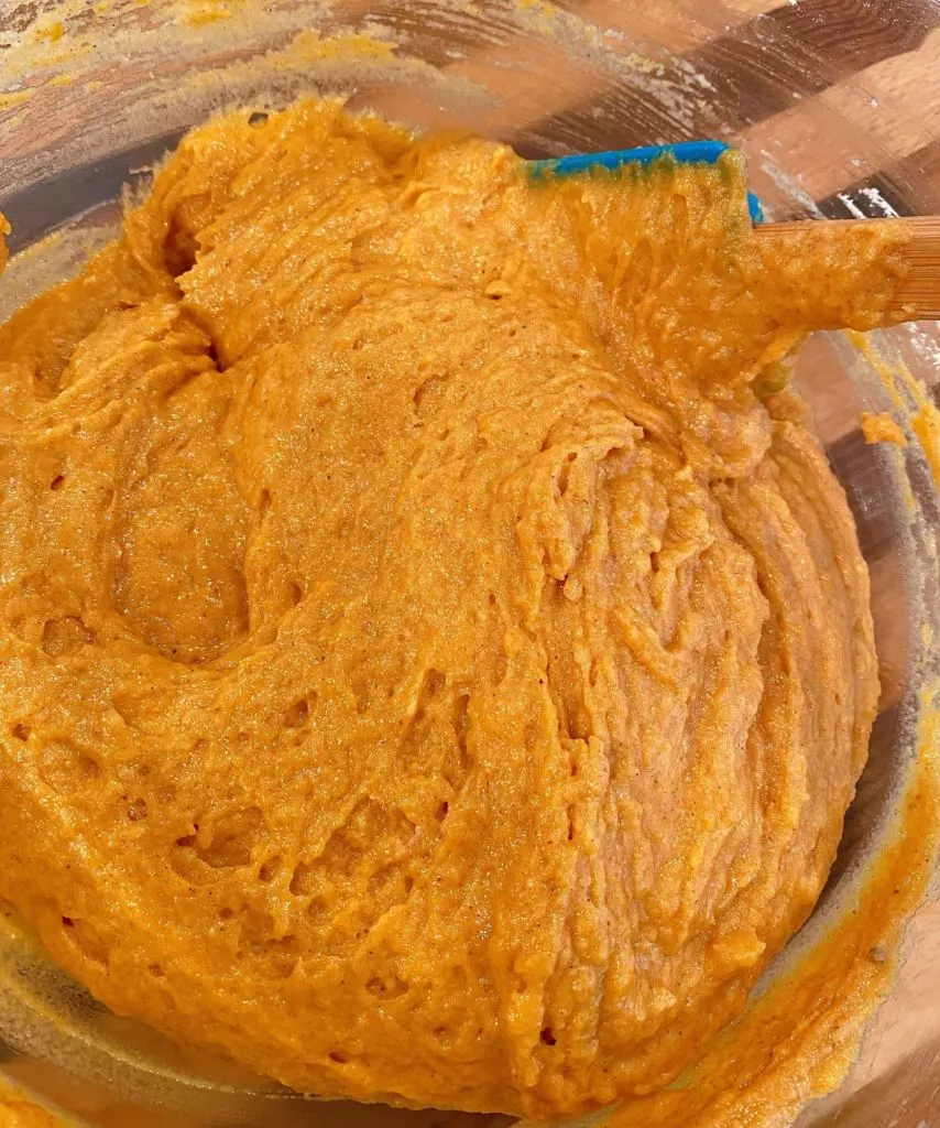 Stirring wet ingredients into dry in the mixing bowl.