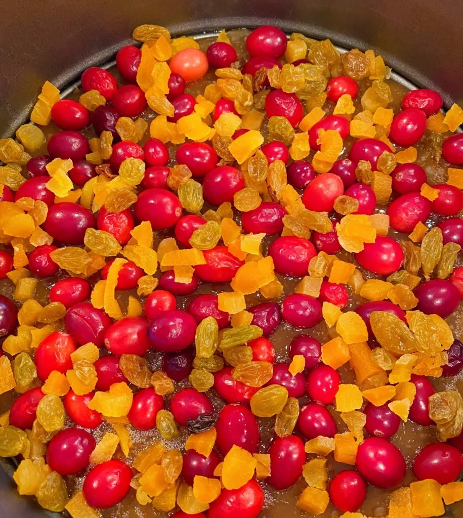 Apricots and Golden Raisins added to cranberry topping in springform pan.