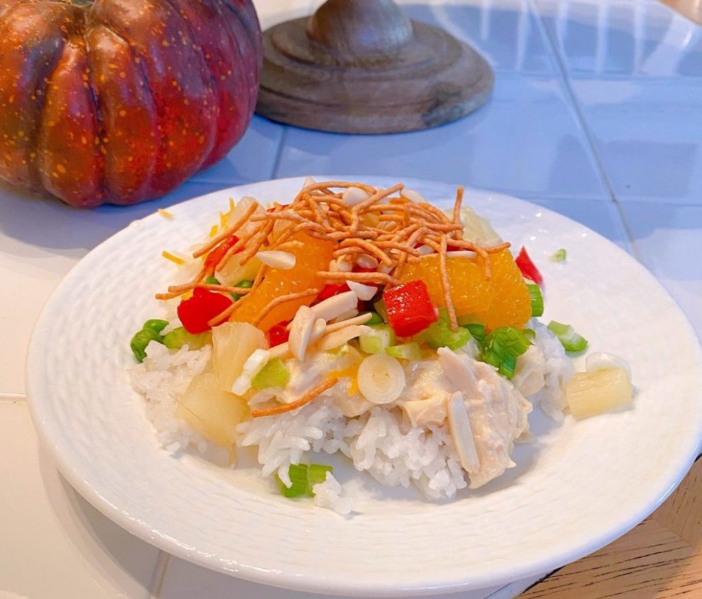 Hawaiian Haystacks on a white plate on a kitchen table with Fall decor around it.