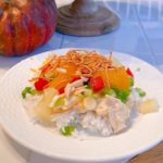 Hawaiian Haystacks on a white plate on a kitchen table with Fall decor around it.