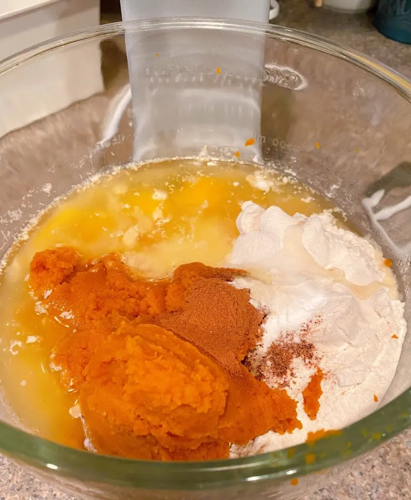 Pumpkin bread ingredients in the bowl of the mixer.