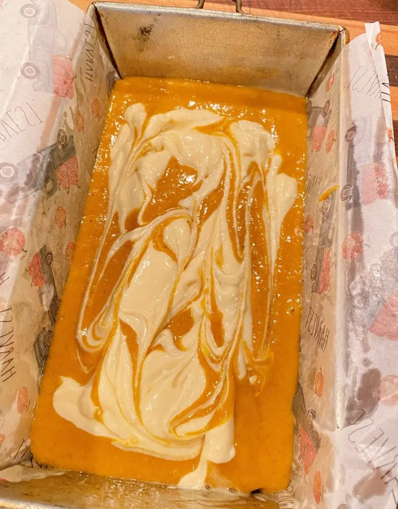 Cream cheese swirled through pumpkin bread batter. 