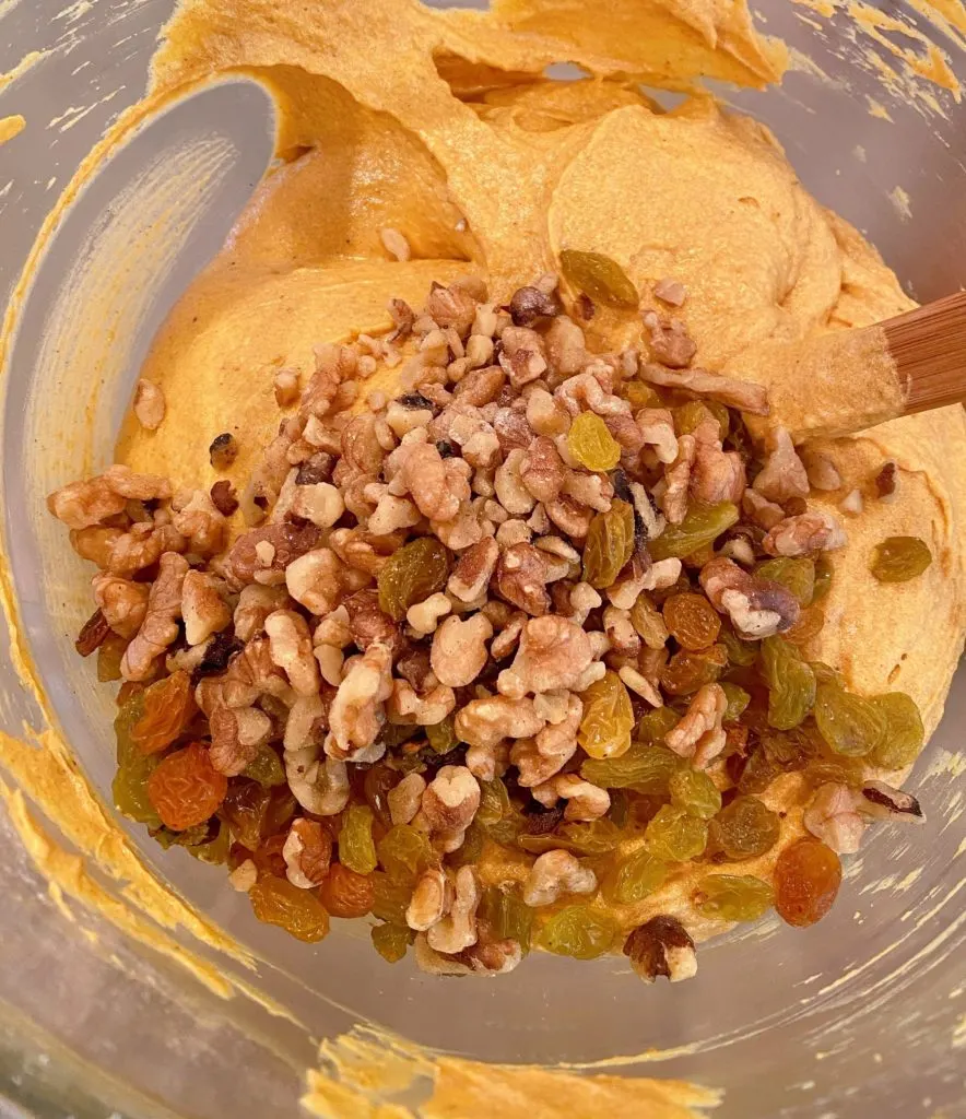 Walnuts and Golden Raisins being added to cake batter. 