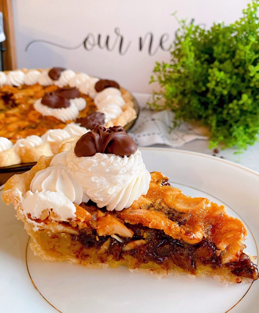 Slice of Pie on dessert plate with whole pie in the background.