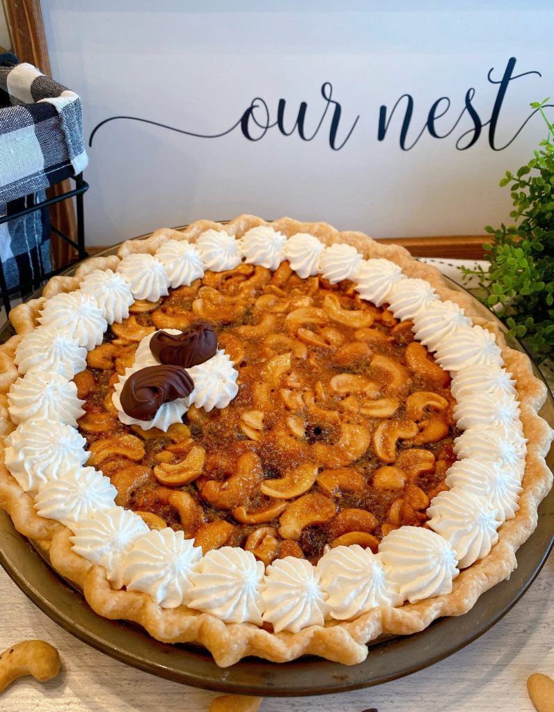 Whole Pie with whipped cream garnish and chocolate covered cashews.