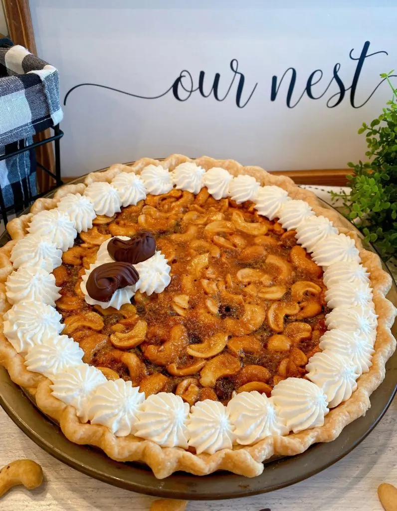 Whole Pie with whipped cream garnish and chocolate covered cashews.
